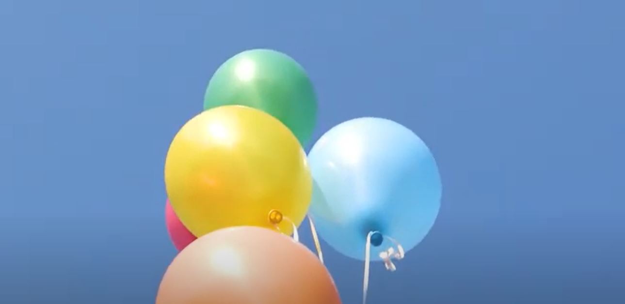 Colorful balloons flying in a blue sky free stock video