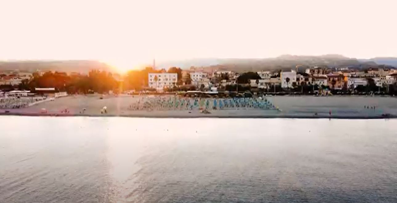 Stock footage of a coastal city with a beach and sunset